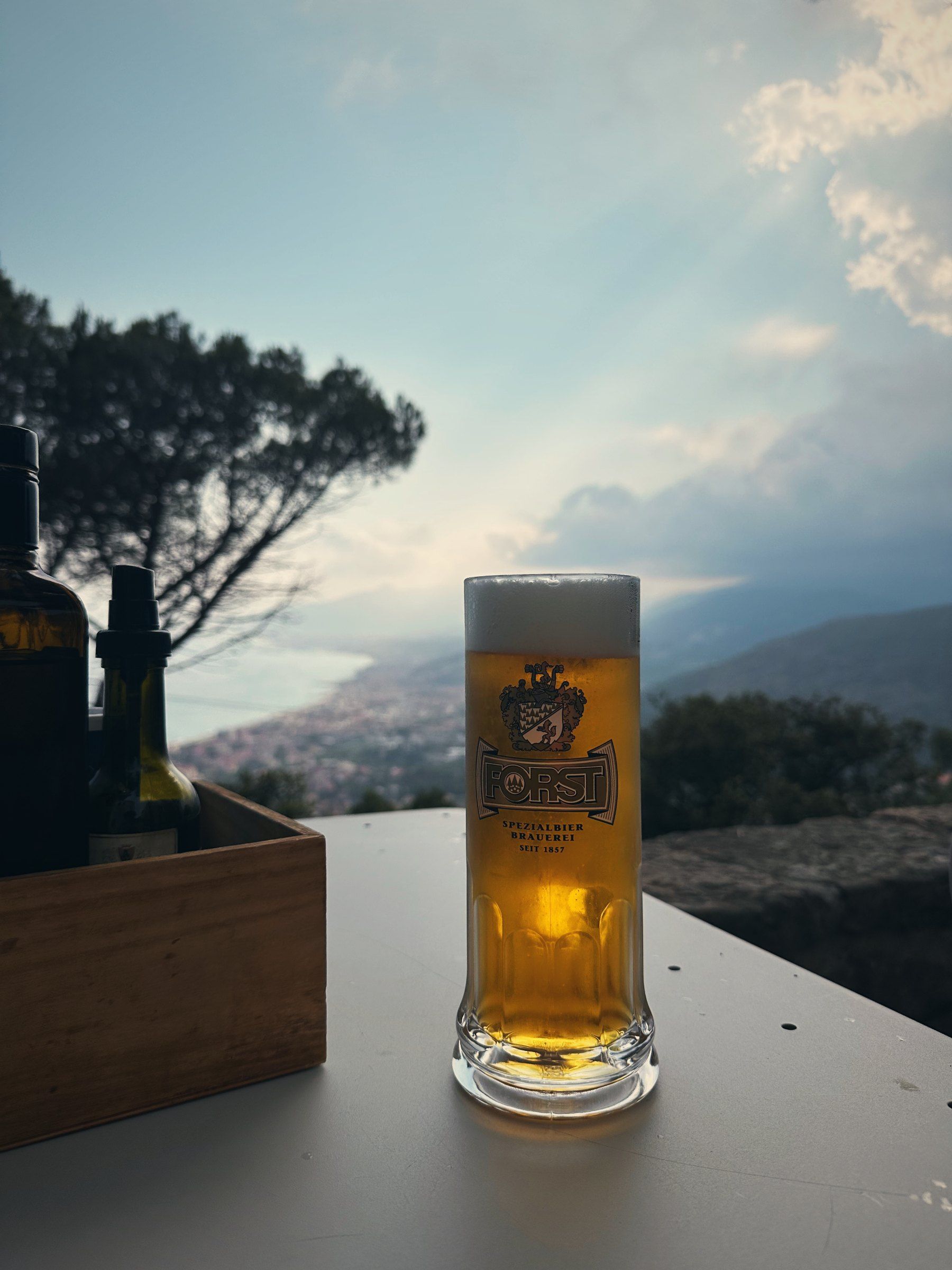 Ein Glas Bier auf einer Terrasse über der Bucht