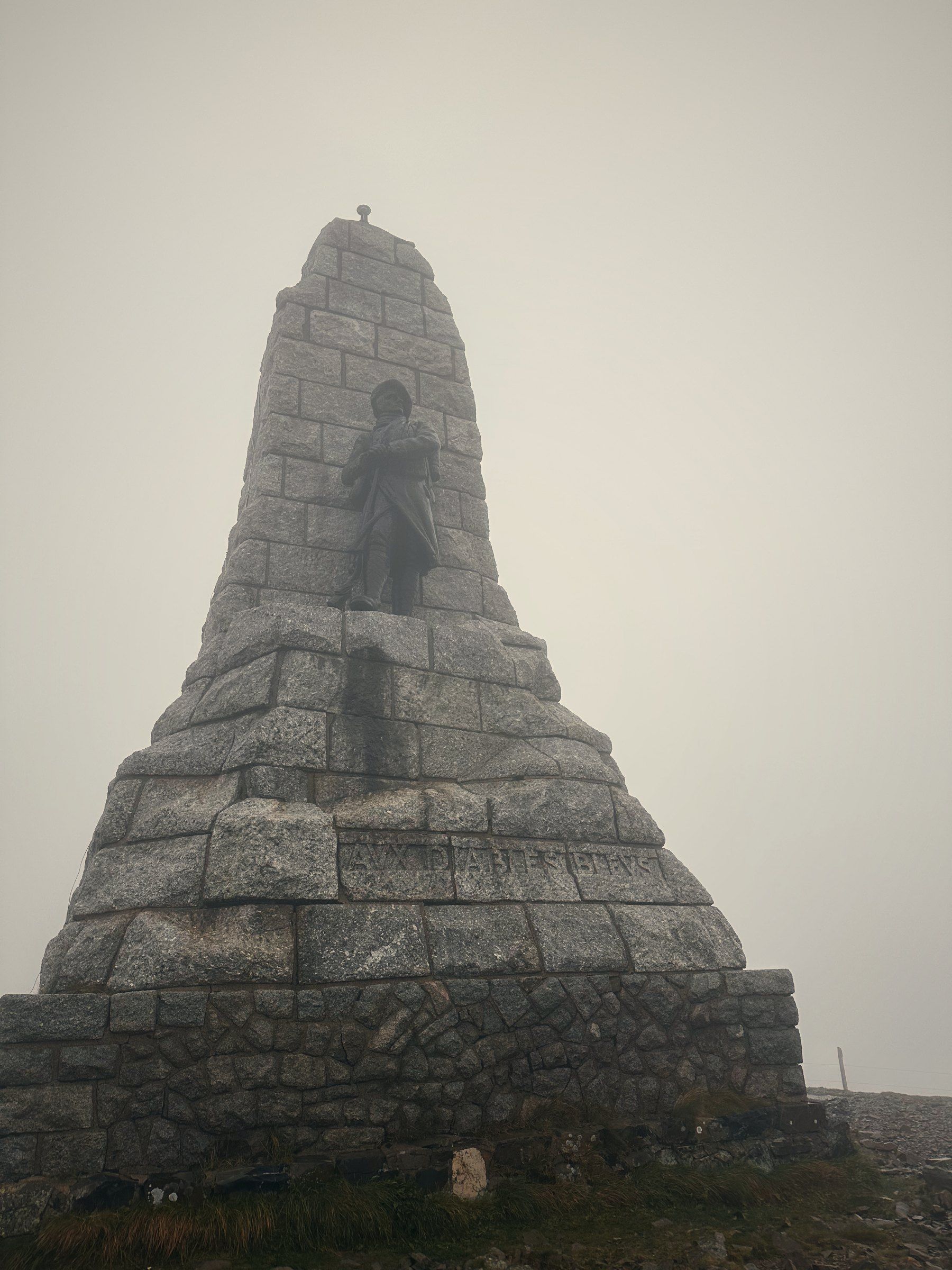 Monument de pierre dans le brouillard au sommet