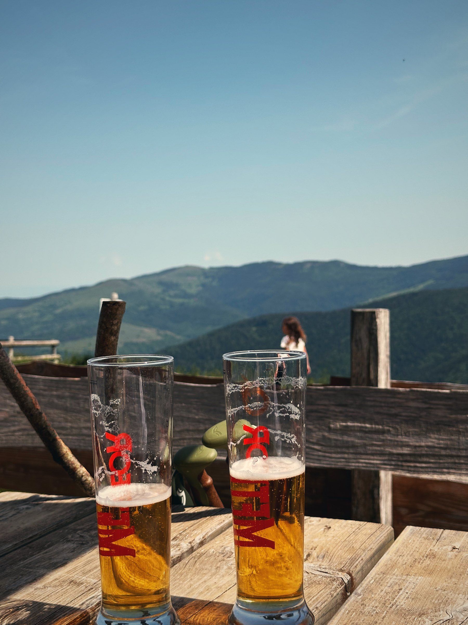 Zwei Gläser auf einem Holztisch mit Blick über die Vogesen