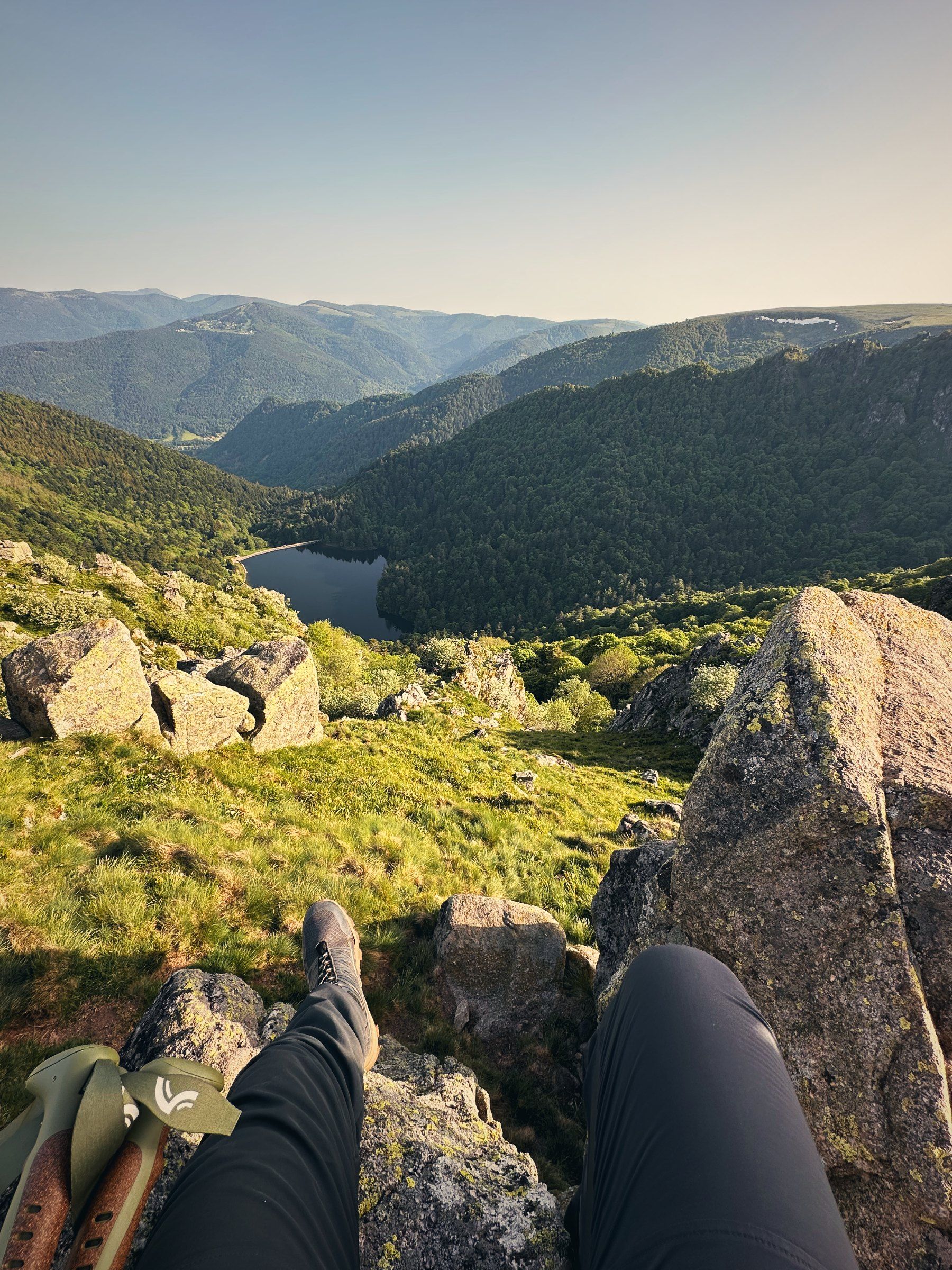 Blick von einem Felsen hinunter auf See und Täler