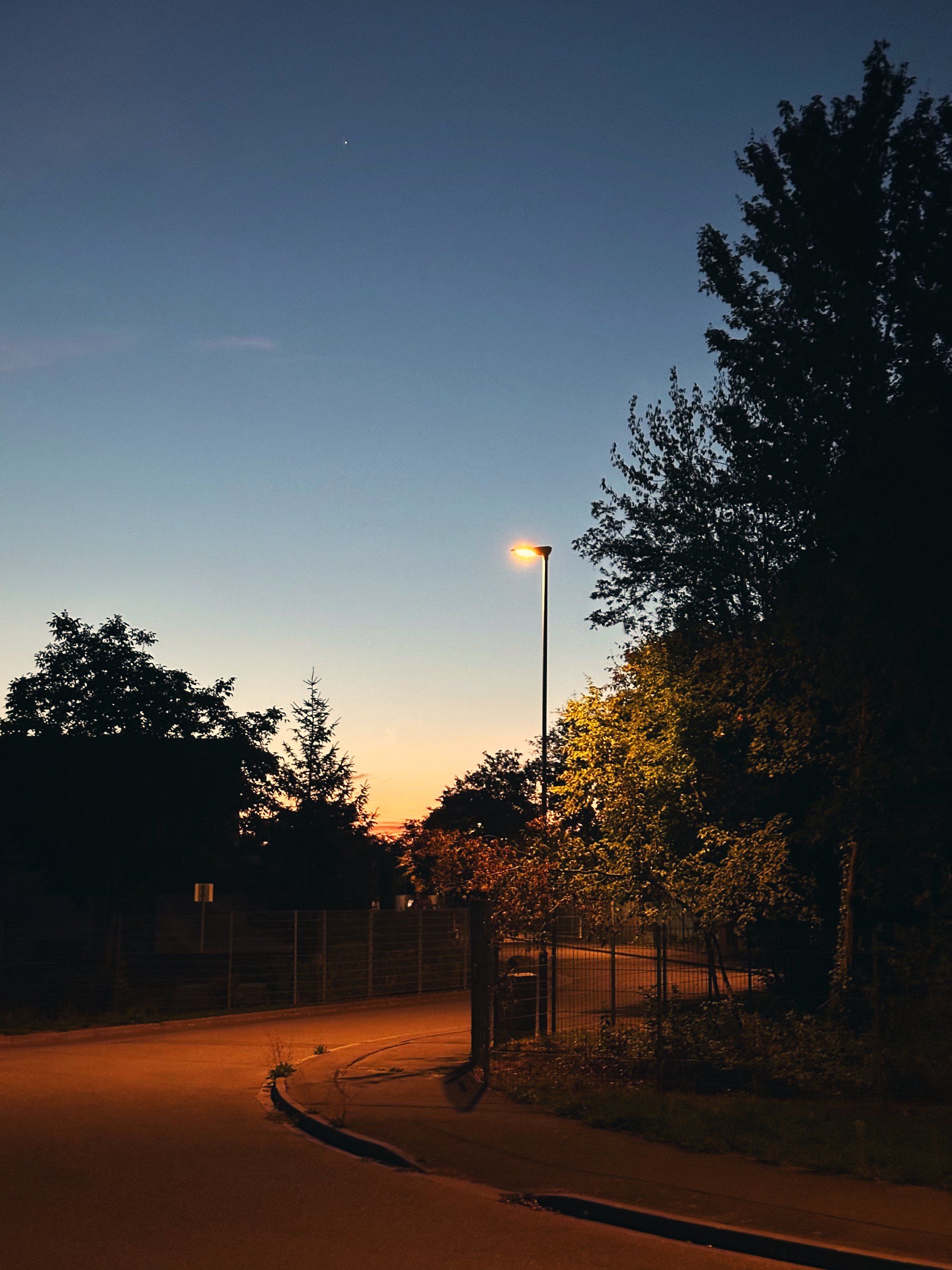 Morgendämmerung über einer Straße mit Laternen