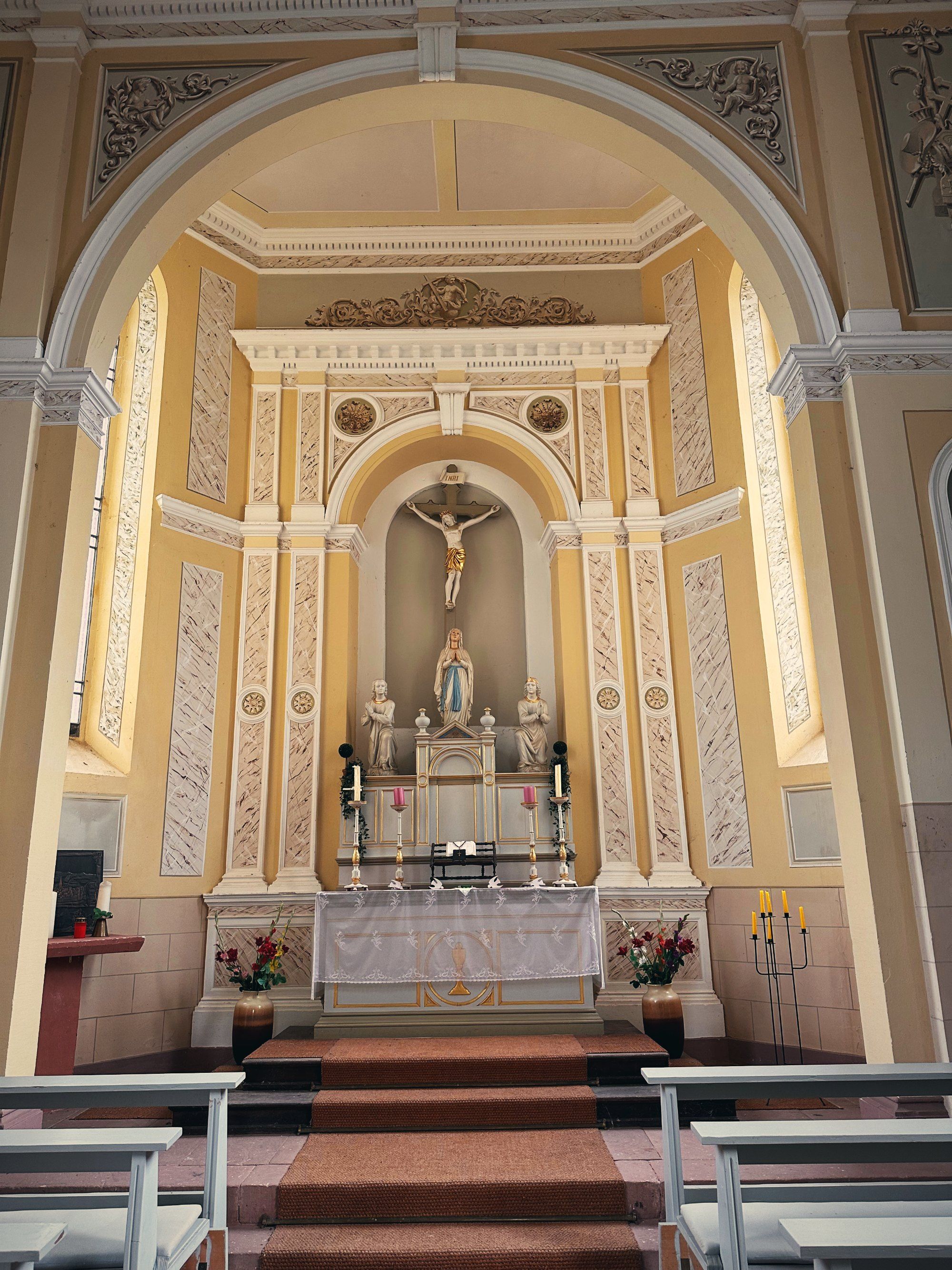 Innenraum einer hellen Kapelle mit Altar