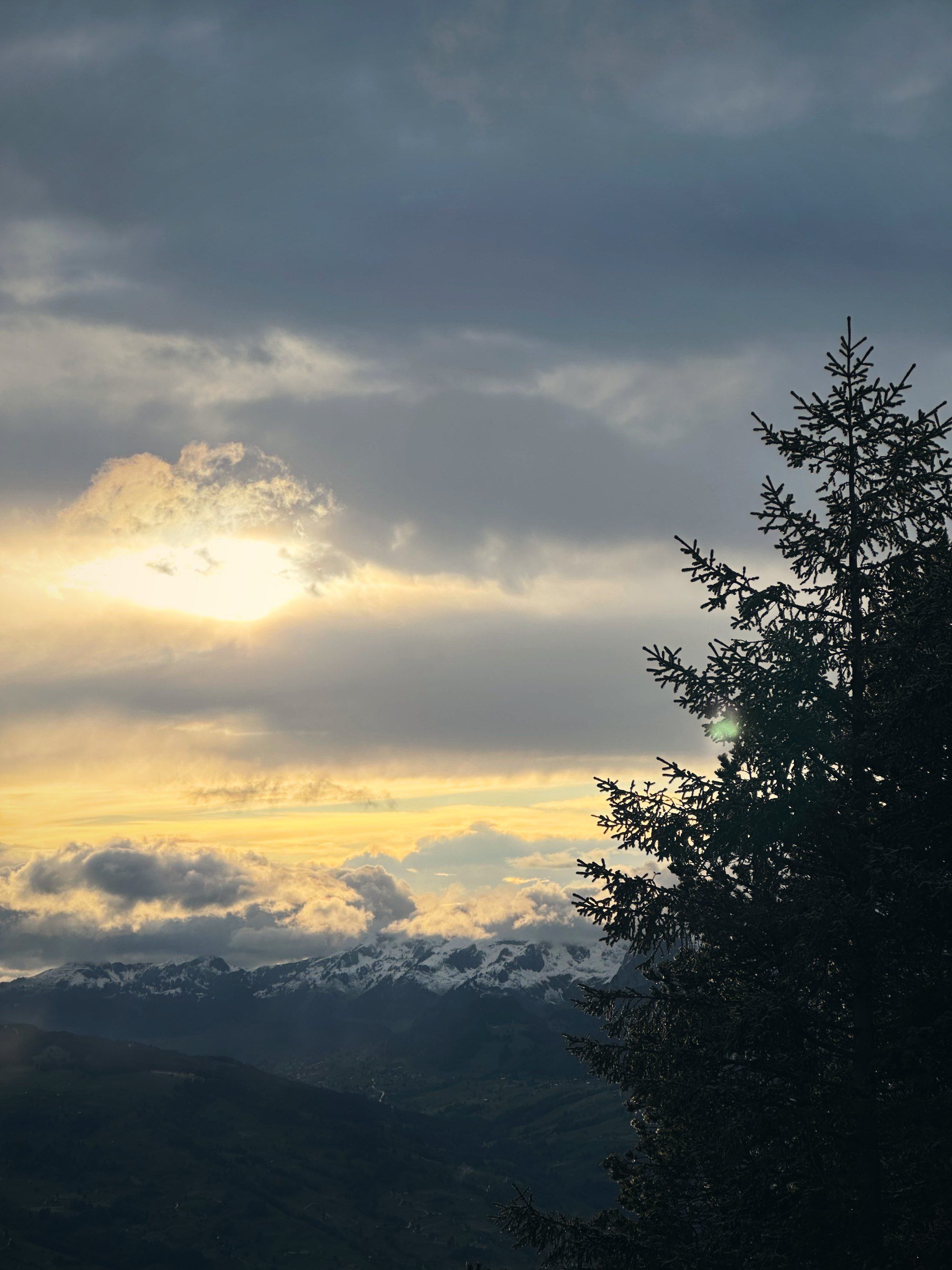 Abendsonne hinter Wolken über den Bergen