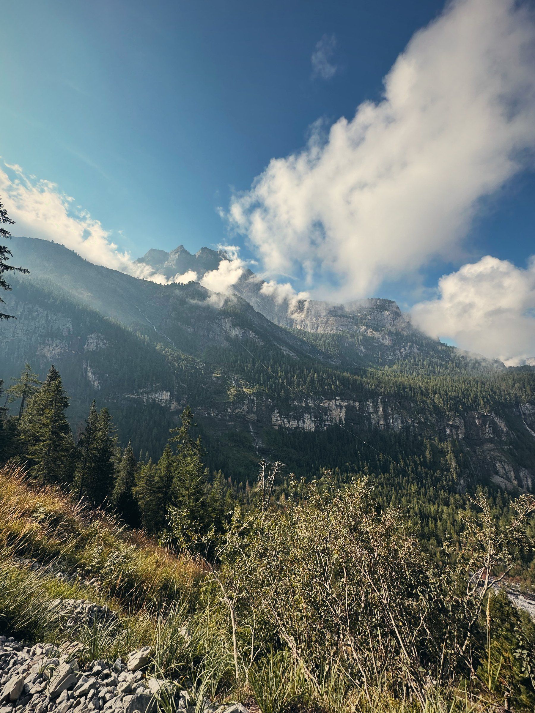 Berge mit Wolken über grünen Hängen