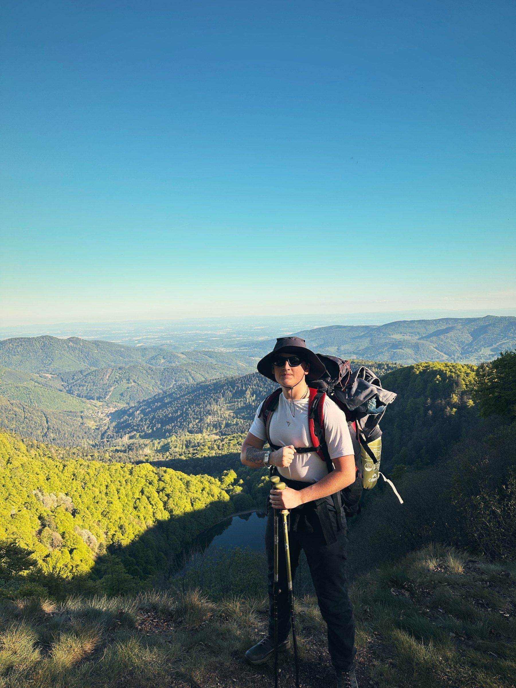 Tea mit Rucksack und Hut über dem Tal